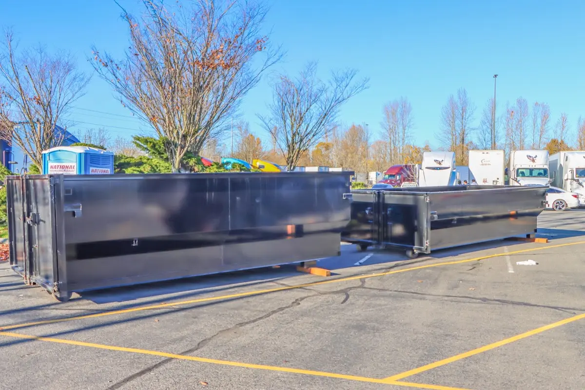 Professional dumpster rental service with roll-off container on residential driveway in Nelson